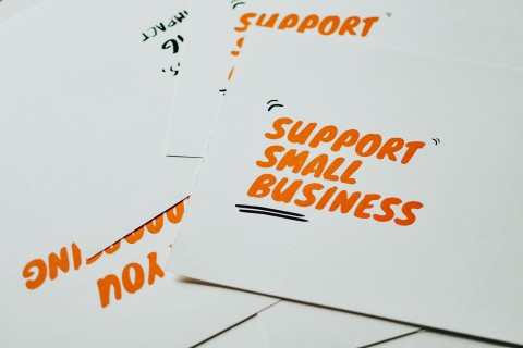 Cards that say "support small business" in orange hand-lettering/bubble letters